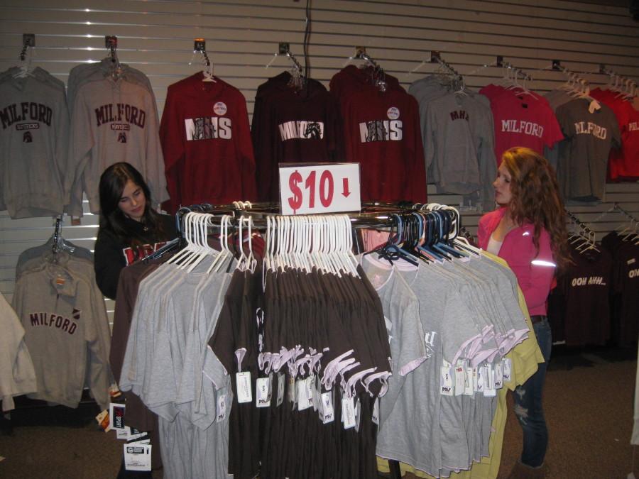 Students+Braedyn+Johnson+and+Katie+Hutchinson+search+through+the+merchandise+in+the+School+Store.+The+School+Store+sells+a+variety+of+t-shirts%2C+sweatshirts%2C+and+other+Milford+Spirit+Wear.