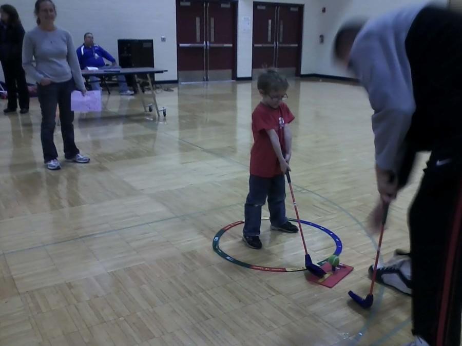 Golf was another activity in this event. The kids tried to hit gym teacher Mr. Arnold, who was holding a target, with a golf ball. Other physical education teachers helped the kids with their form.