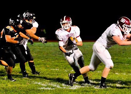 Brandon Wallace carries the ball past Brighton defenders in Milford’s past season. Wallace will be attending the University of Dayton and will play the position of running back.