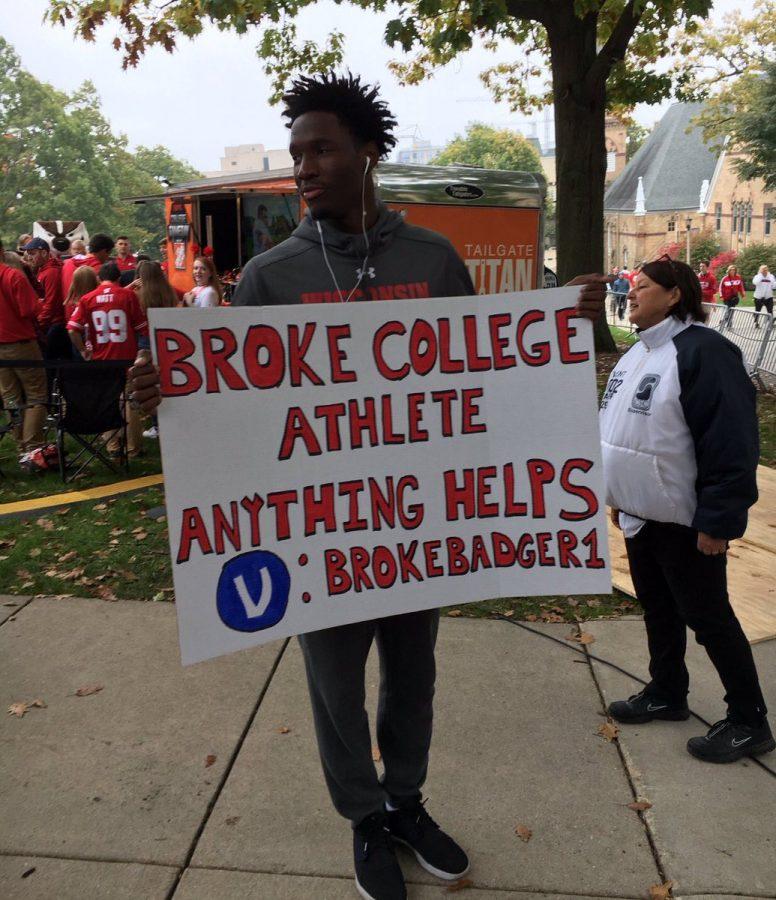 Nigel+Hayes%2C+a+University+of+Wisconsin+basketball+player%2C+holds+a+sign+protesting+the+NCAA+at+College+Gameday.