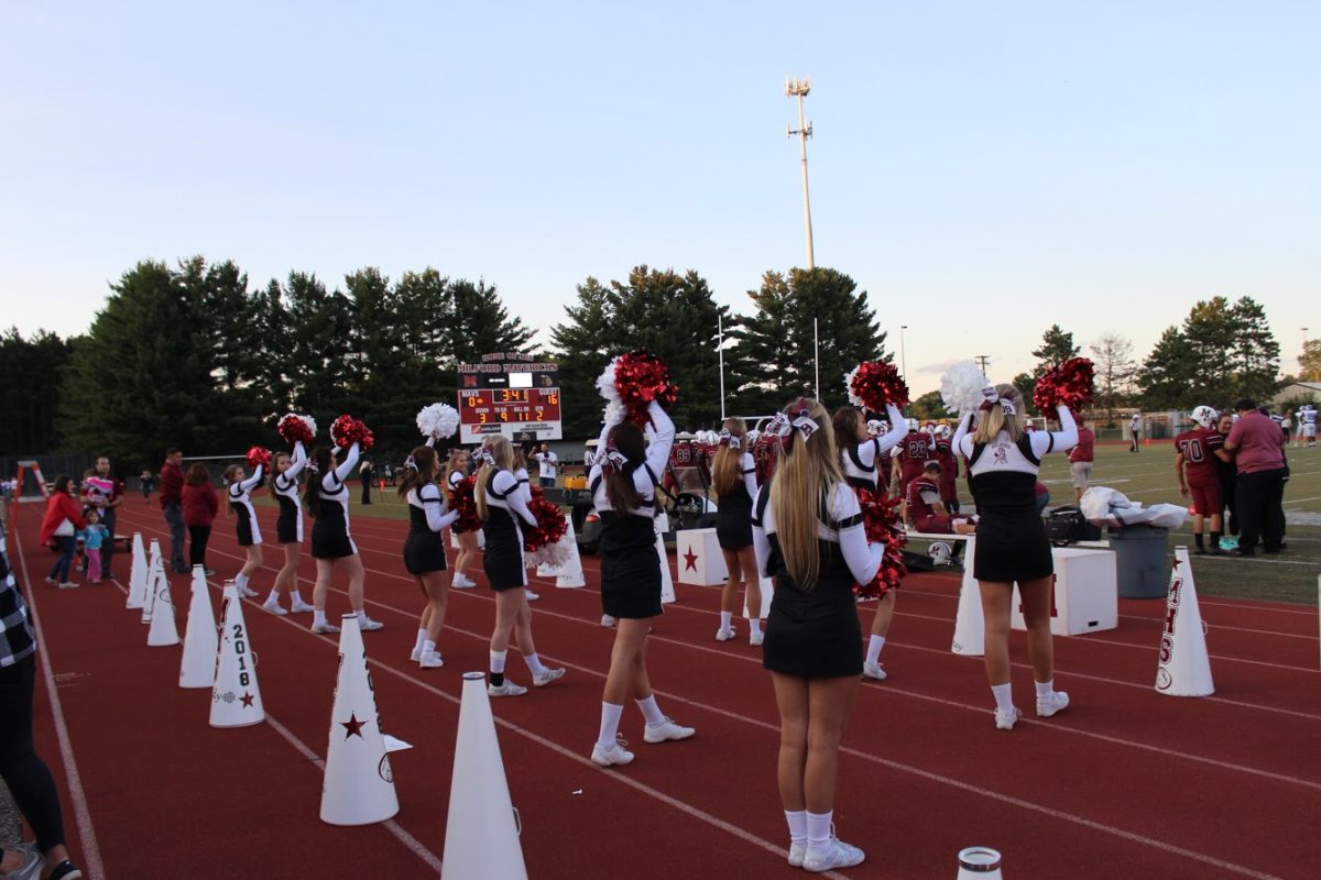 The Milford cheer team cheers on their Mavericks under the lights.