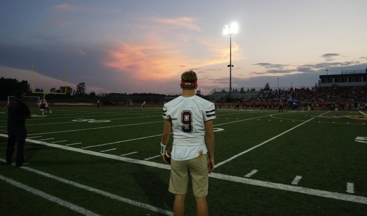 Injured player Kyle Soderberg cheers on team from the sidelines.