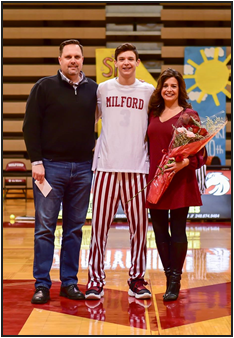 Senior Aiden Warzecha stands with his parents while being honored on Senior Night