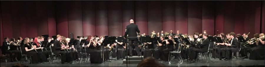 Conductor Jim Otto conducting combined wind ensembles.