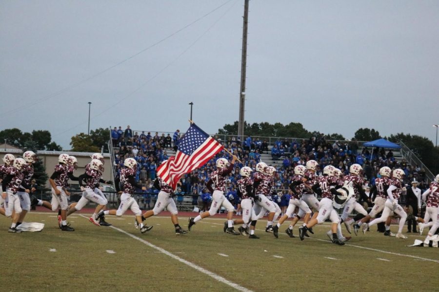 The Varsity Football Team runs onto the field Lead by Jake Miller holding up the flag. (All photos courtesy of Jerry Rea)
