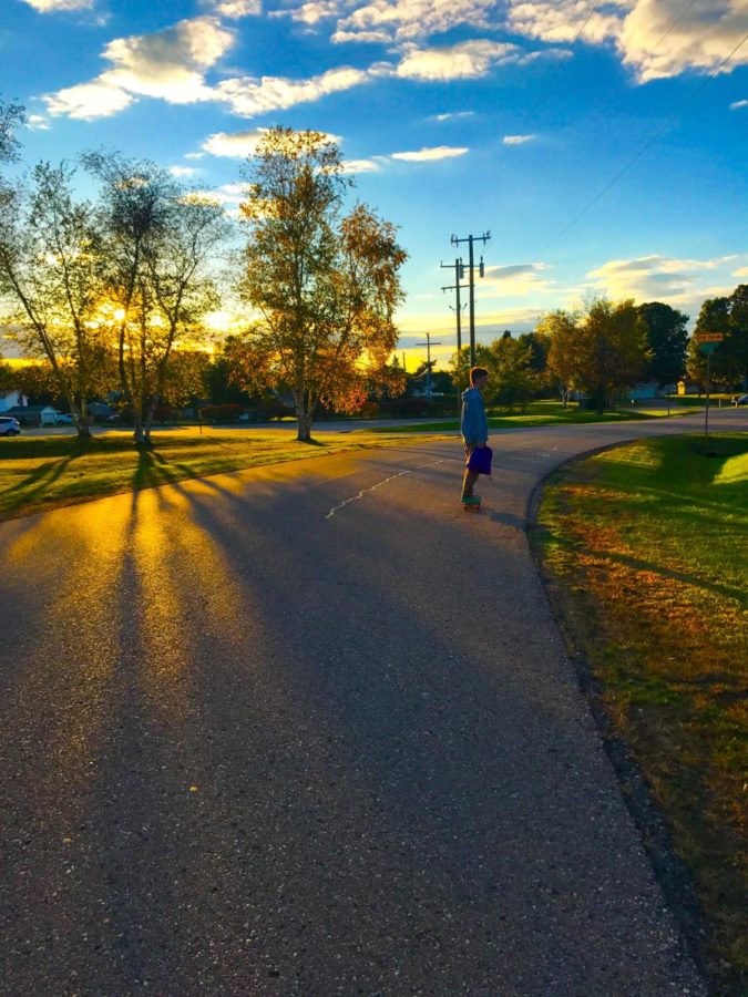 Junior Ryan Wyskiel Skating down a
road.