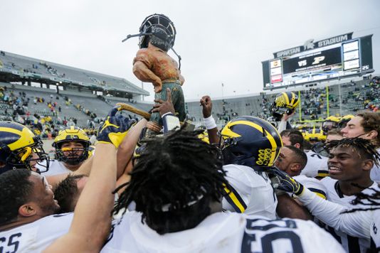 Michigan Wolverines celebrating with the Paul Bunyan Trophy, courtesy of Detroit Free Press