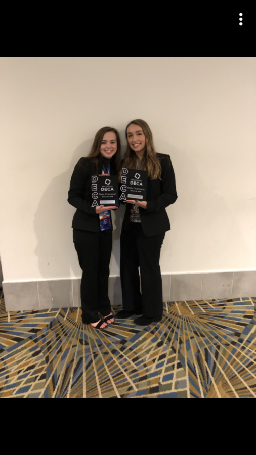 DECA members Anna Fischer along with Alexis Camilleri holding their state champion plaque.
