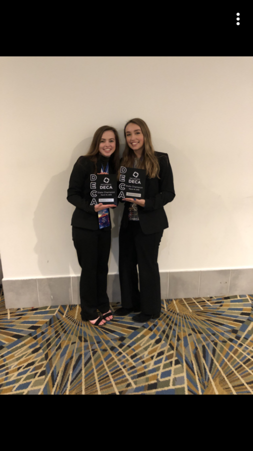 DECA members Anna Fischer along with Alexis Camilleri holding their state champion plaque.