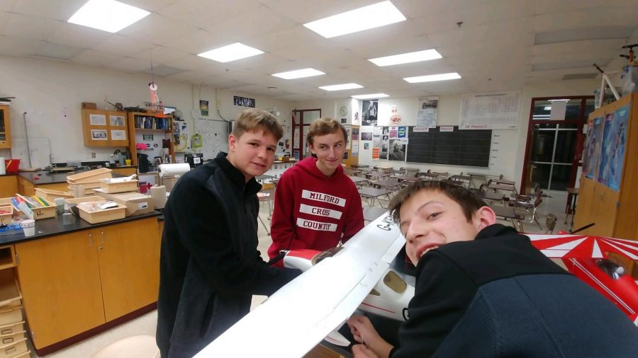 Left to right) Evan Thompson, Dylan Hoorn, and Nick Blanchard working on an aircraft  