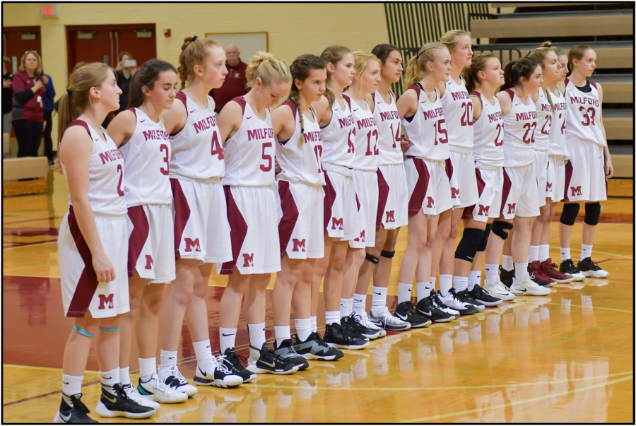 Girls JV basketball team lined up during the National Anthem
