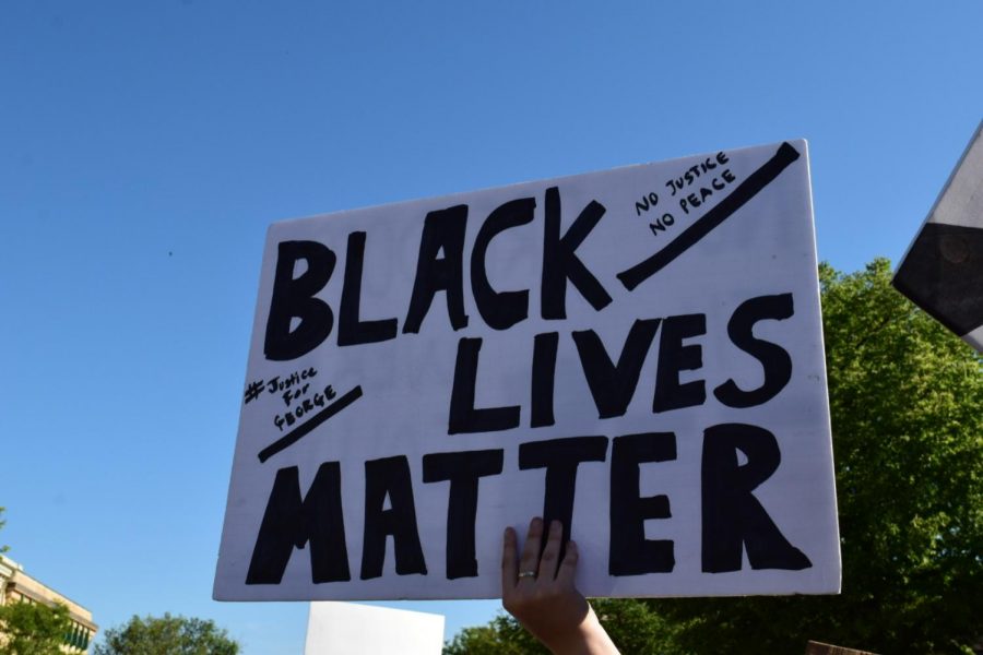A person at the Black Lives Matter protest in Milford, MI holds up a homemade sign.