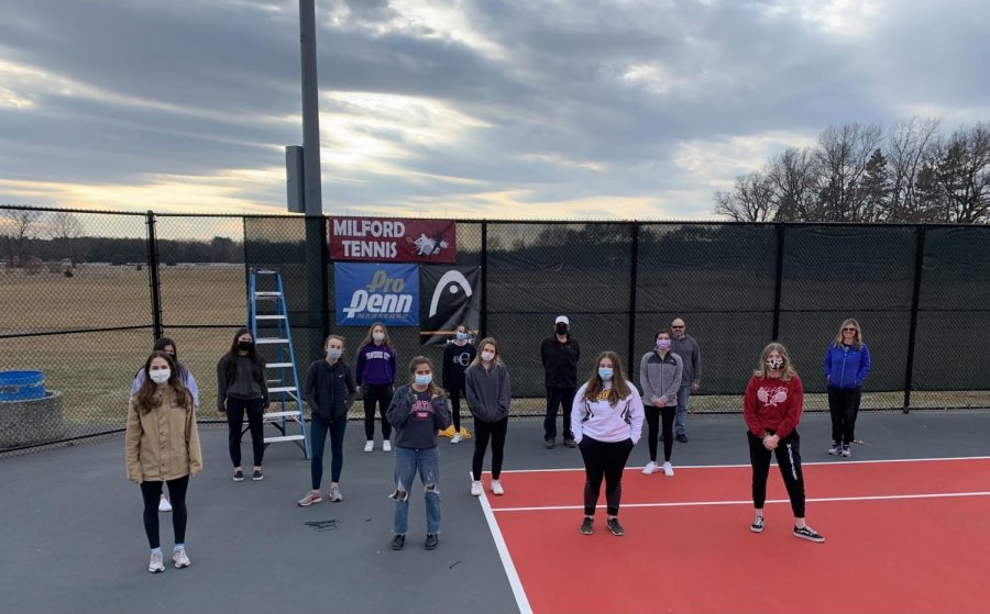 The girls putting up windscreens on the courts in preparation for their season.