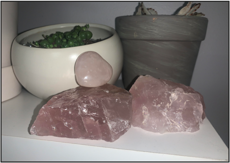 An assortment of rose quartz crystals, arranged on a bedside table to help open the heart chakra thus fueling higher self-love (Photo by Annabelle Stewart) 
