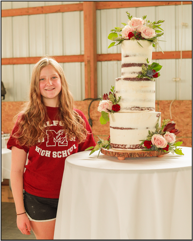 Kennedy Russell standing next to one of her wedding cakes (Photo courtesy of Kennedy Russell)