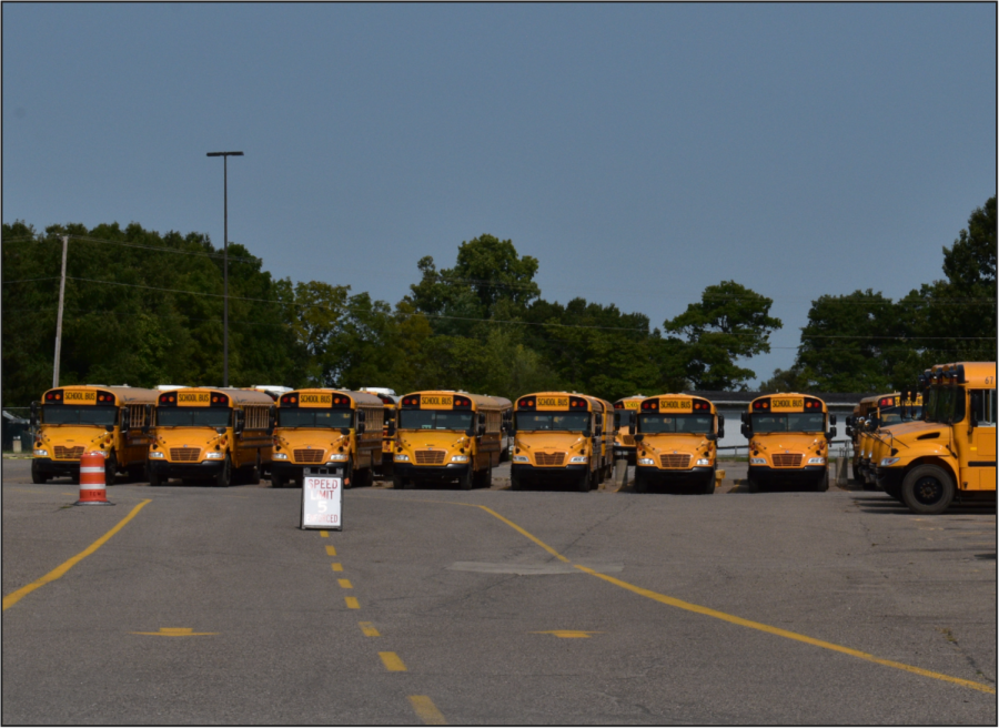 Huron Valley Schools buses parked in the lot at Milford High School.