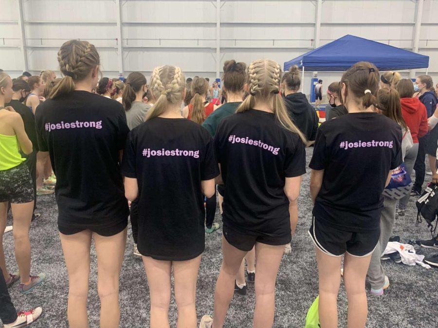 Juniors Brooklyn Wolcott, Audrey Verkerke, Jacie Remtema, and Grace Harkenrider wearing track warm-up shirts at an indoor meet 