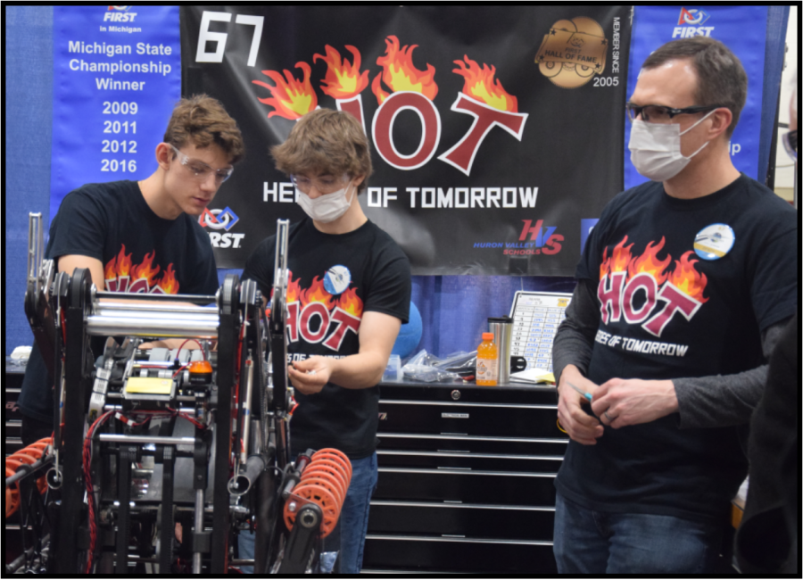 Ryan Hociota, Grant Stec and Jim Meyer work on the robot in between matches. 