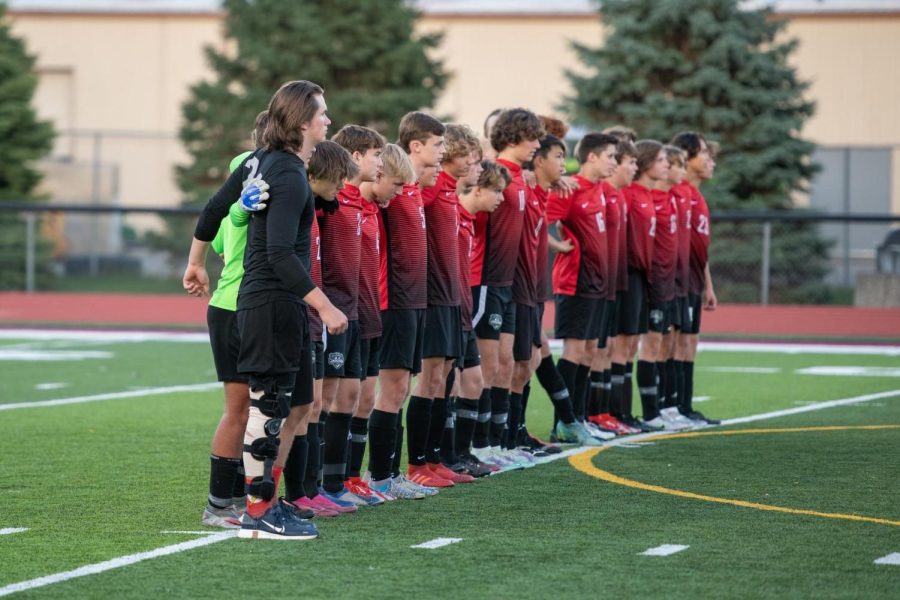 Milford soccer stands together during the National Anthem.