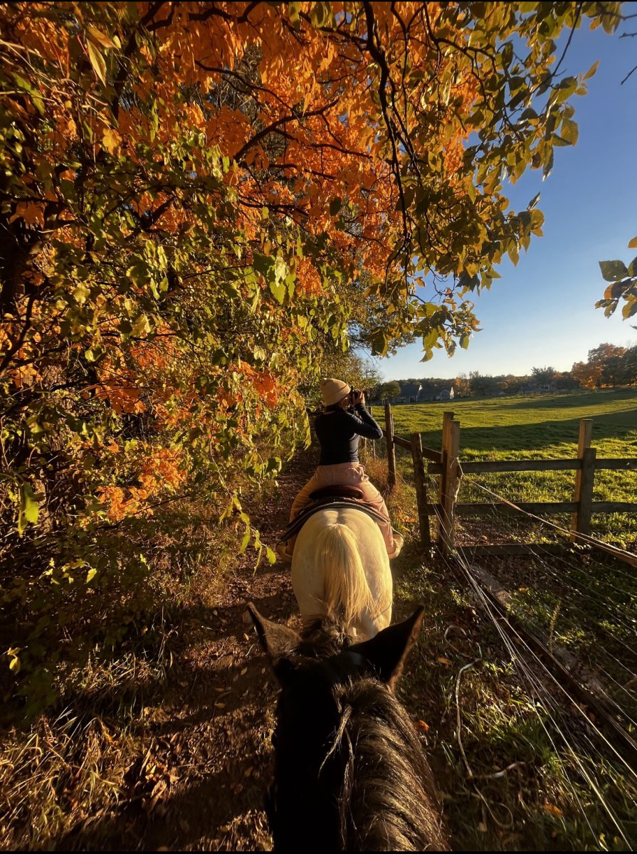 Rylie taking pictures on a fall trail ride